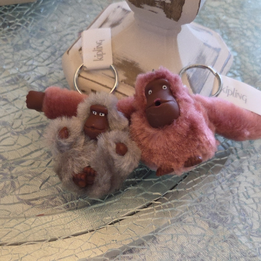 Kipling Plush Monkey Keychains in Pink and Gray